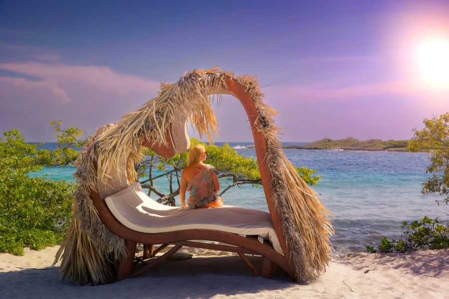 Traveler lounging in front of a Caribbean sunset